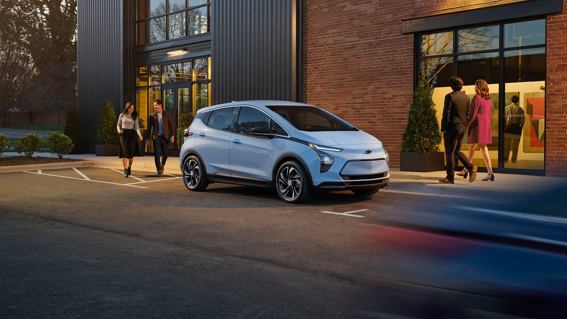 A Chevrolet Bolt electric vehicle parked in front of a modern building